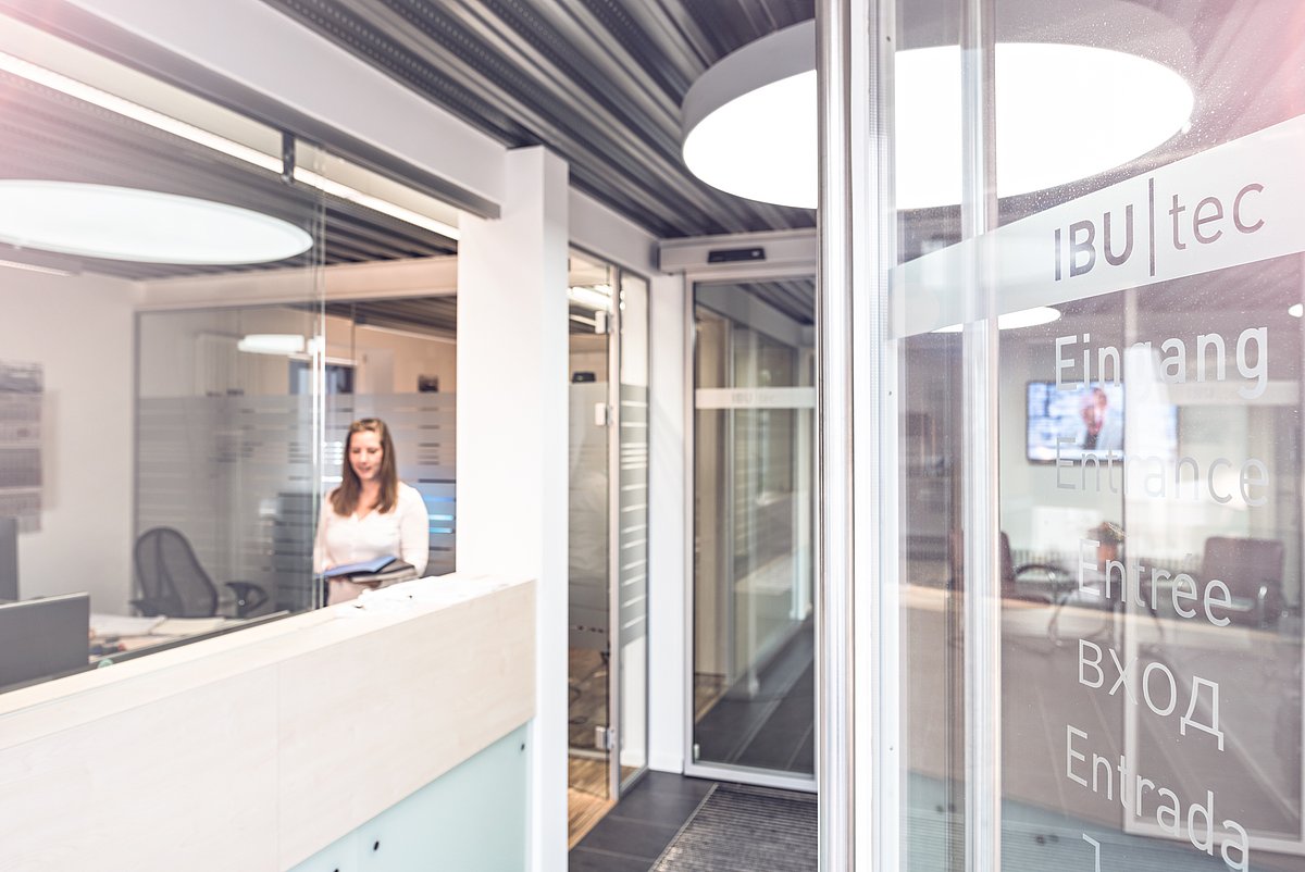 Reception and welcome room of IBU-tec in Weimar with a receptionist and a invitingly open door